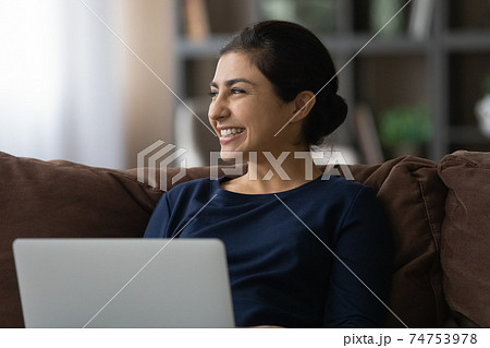 Smiling Indian woman work on laptop at home Smiling Indian woman work on laptop at home 74753978