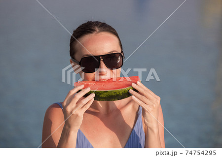 Very beautiful woman with watermelon in the pool 74754295