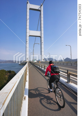 美しい瀬戸内海でサイクリングを楽しむ人　ナショナルサイクルルート「しまなみ海道サイクリングロード」 74754303