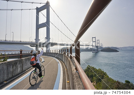 美しい瀬戸内海でサイクリングを楽しむ人　ナショナルサイクルルート「しまなみ海道サイクリングロード」 74754304