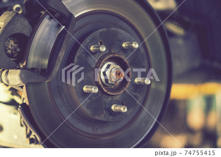 The hub of a wheel in a car service. Suspended car with no wheels. Suspension of car in service room.The car lift up by lifter for maintenance suspension and cleaning parts. Close up. toned 74755415