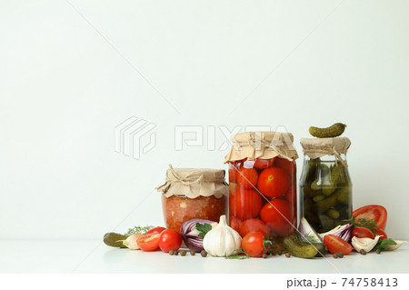 Pickled tomatoes, cucumbers, adjuca and ingredients on white background Pickled tomatoes, cucumbers, adjuca and ingredients on white background 74758413