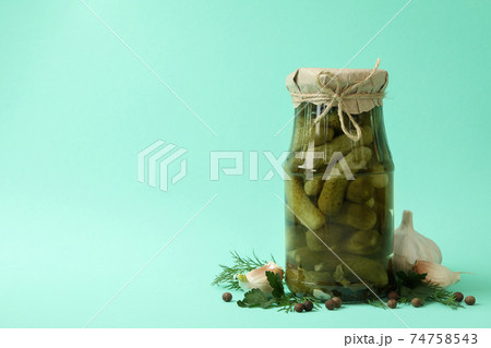 Jar of pickled cucumbers and ingredients on mint background Jar of pickled cucumbers and ingredients on mint background 74758543