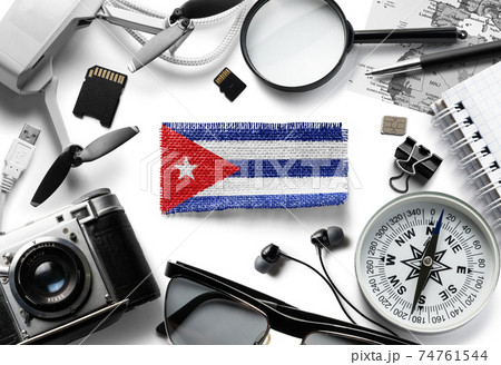 Flag of Cuba and travel accessories on a white background. Flag of Cuba and travel accessories on a white background. 74761544