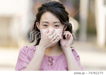 ピンクの不織布マスクをつけた若い女性 ピンクの不織布マスクをつけた若い女性 74762275