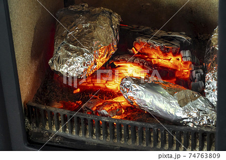 薪ストーブで焼き芋を焼くの写真素材