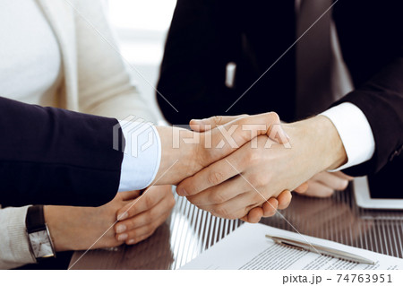 Business people shaking hands after contract signing in modern office. Teamwork, partnership and handshake concept 74763951
