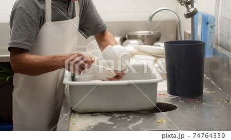 Man washing dish 74764359