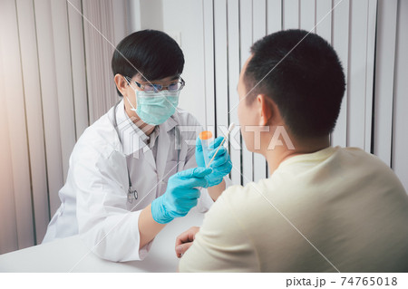 Doctor or medical staff is collecting secretions from patient for examination in the lab. Pandemic Coronavirus, COVID-19. Doctor or medical staff is collecting secretions from patient for examination in the lab. Pandemic Coronavirus, COVID-19. 74765018