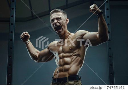 Energy caucasian strong athlete screaming in gym 74765161
