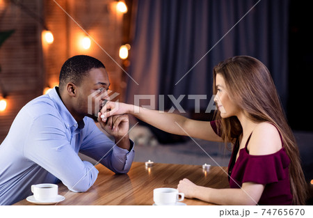 Happy Interracial Couple Flirting During Romantic Date In Restaurant Happy Interracial Couple Flirting During Romantic Date In Restaurant 74765670