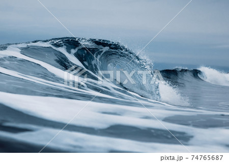 Perfect ocean waves with blue water cloudy dark sky. Perfect ocean waves with blue water cloudy dark sky. 74765687