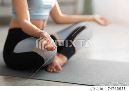 Cropped of woman in sportswear meditating at home 74766053