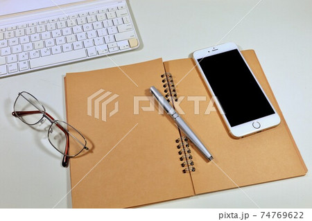 ビジネスイメージ　デスクの上のノートとスマホ 74769622