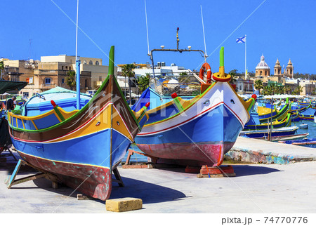 traditional colorful fishing boats luzzu in Malta - Marsaxlokk village traditional colorful fishing boats luzzu in Malta - Marsaxlokk village 74770776
