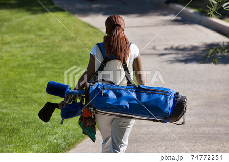 Woman Carrying Golf Club Bag Woman Carrying Golf Club Bag 74772254