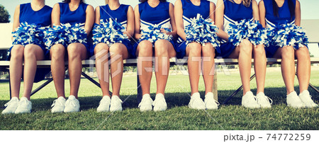 Cheerleading Squad Sitting on Bench 74772259