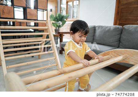 a baby climbing on pikler triangle toys 74774208