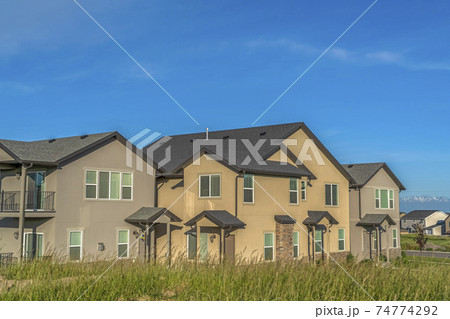 Exterior view of multi storey homes with balconies and porticos against blue sky Exterior view of multi storey homes with balconies and porticos against blue sky 74774292