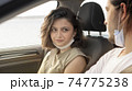 Happy young couple, friends with face masks sitting in the car and talking each other. Road trip in new normality. Corona virus pandemic concept. 74775238