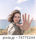 Beautiful happy young woman making stop sign with her hand. 74775244