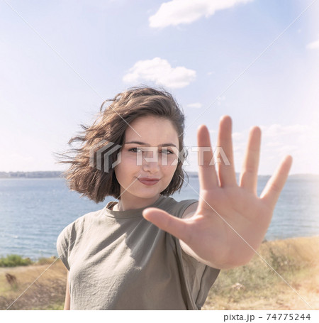 Beautiful happy young woman making stop sign with her hand. Beautiful happy young woman making stop sign with her hand. 74775244
