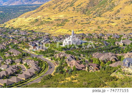 Salt Lake City Utah suburbs with a white temple towering over houses and roads 74777155