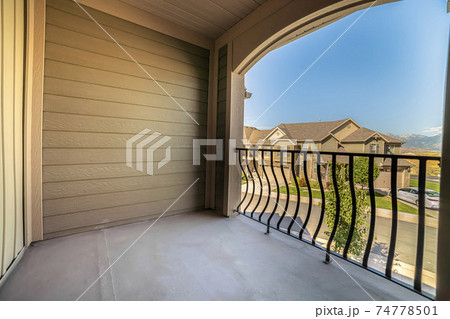 Balcony of home overlooking houses and mountain against blue sky on a sunny day 74778501