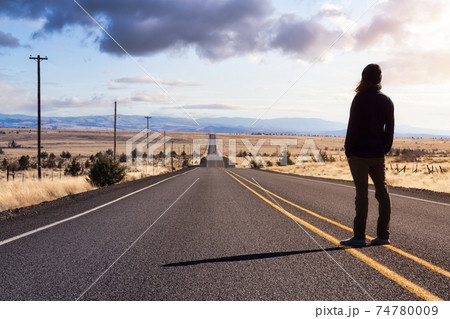 Man is standing in the middle of the long road. Man is standing in the middle of the long road. 74780009