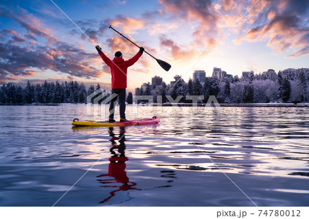 Adventurous male is paddle boarding near Stanley Park Adventurous male is paddle boarding near Stanley Park 74780012