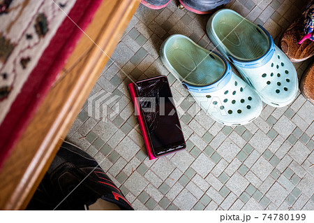 玄関でスマホを落として画面が割れる 74780199