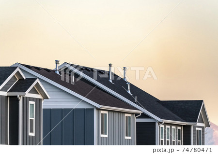 Roofs of modern urban houses at sunset Roofs of modern urban houses at sunset 74780471