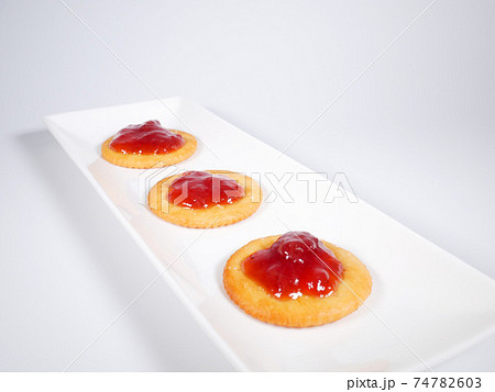 いちごジャムを乗せた丸いクラッカー いちごジャムを乗せた丸いクラッカー 74782603
