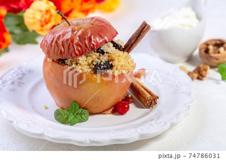 Baked spicy apple with couscous and dried berries. 74786031