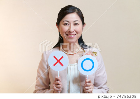 マルバツカードを持った正装した中年女性 74786208