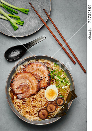 A Shoyu Ramen in gray bowl on concrete table top. Japanese cuisine meat noodle soup with chashu pork A Shoyu Ramen in gray bowl on concrete table top. Japanese cuisine meat noodle soup with chashu pork 74789306