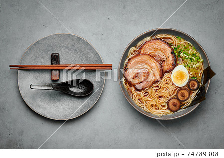 A Shoyu Ramen in gray bowl on concrete table top. Japanese cuisine meat noodle soup with chashu pork 74789308