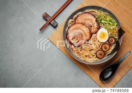 A Shoyu Ramen in gray bowl on concrete table top. Japanese cuisine meat noodle soup with chashu pork 74789309