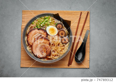 A Shoyu Ramen in gray bowl on concrete table top. Japanese cuisine meat noodle soup with chashu pork A Shoyu Ramen in gray bowl on concrete table top. Japanese cuisine meat noodle soup with chashu pork 74789312