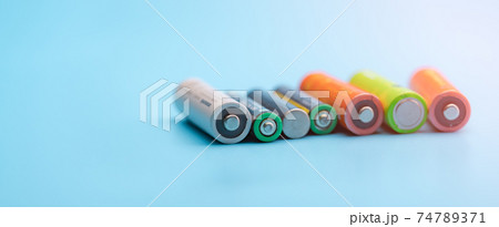 Rechargeable battery on blue background. Selective focus negative terminals of rechargeable lithium-ion batteries. AA and AAA size of old Li-ion battery. Battery recycling concept. Green power energy. 74789371