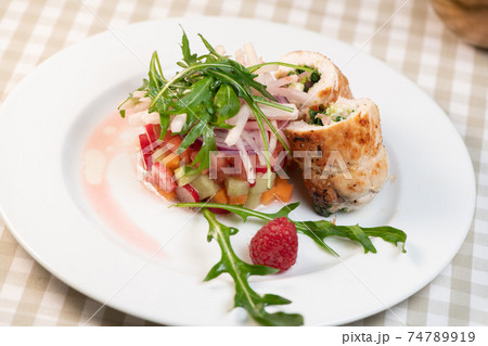 Tartare of fresh diced vegetables and salads in a white plate decorated with a raspberry Tartare of fresh diced vegetables and salads in a white plate decorated with a raspberry 74789919