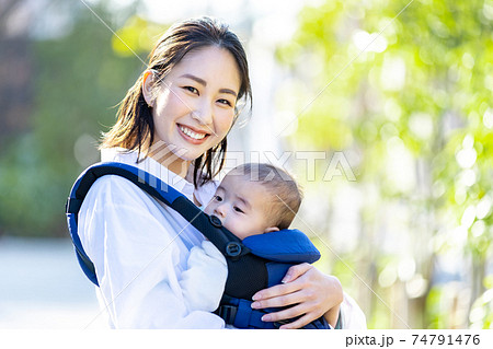 抱っこ紐で育児をする若い女性 74791476