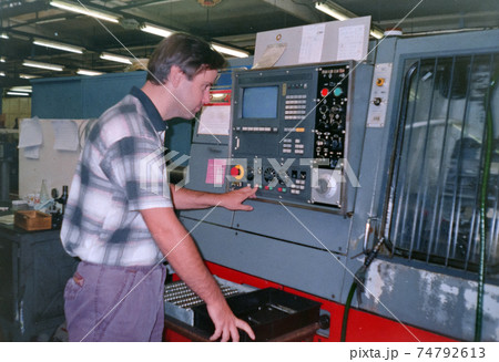 A man operates a numerical control machine in a factory, archive photo, 90s. Czech republic. A man operates a numerical control machine in a factory, archive photo, 90s. Czech republic. 74792613