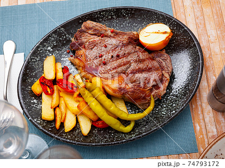 Beef entrecote with fried potatoes, peppers, tomatoes, onion Beef entrecote with fried potatoes, peppers, tomatoes, onion 74793172