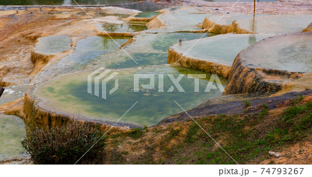 Travertine terraces with hot water of Karahyit Red Springs, Turkey 74793267