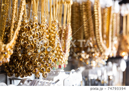 Golden necklaces on showcase in bijouterie shop 74793394