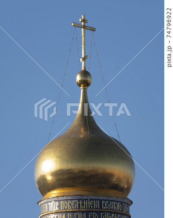 Golden dome with orthodox cross close-up on a blue sky background 74796922
