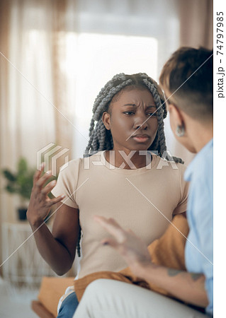 Dark-skinned girl talking to her girlfriend and looking agressive 74797985