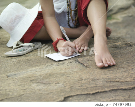 Lowsection Of Woman Writing On Paper Outdoors Lowsection Of Woman Writing On Paper Outdoors 74797992