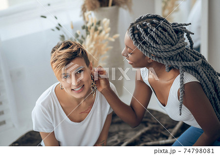 Two girls spending time at home trying on some accessories Two girls spending time at home trying on some accessories 74798081